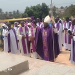 Mgr Aké benissant la tombe